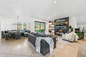 Living room featuring finished concrete flooring, recessed lighting, and a large fireplace
