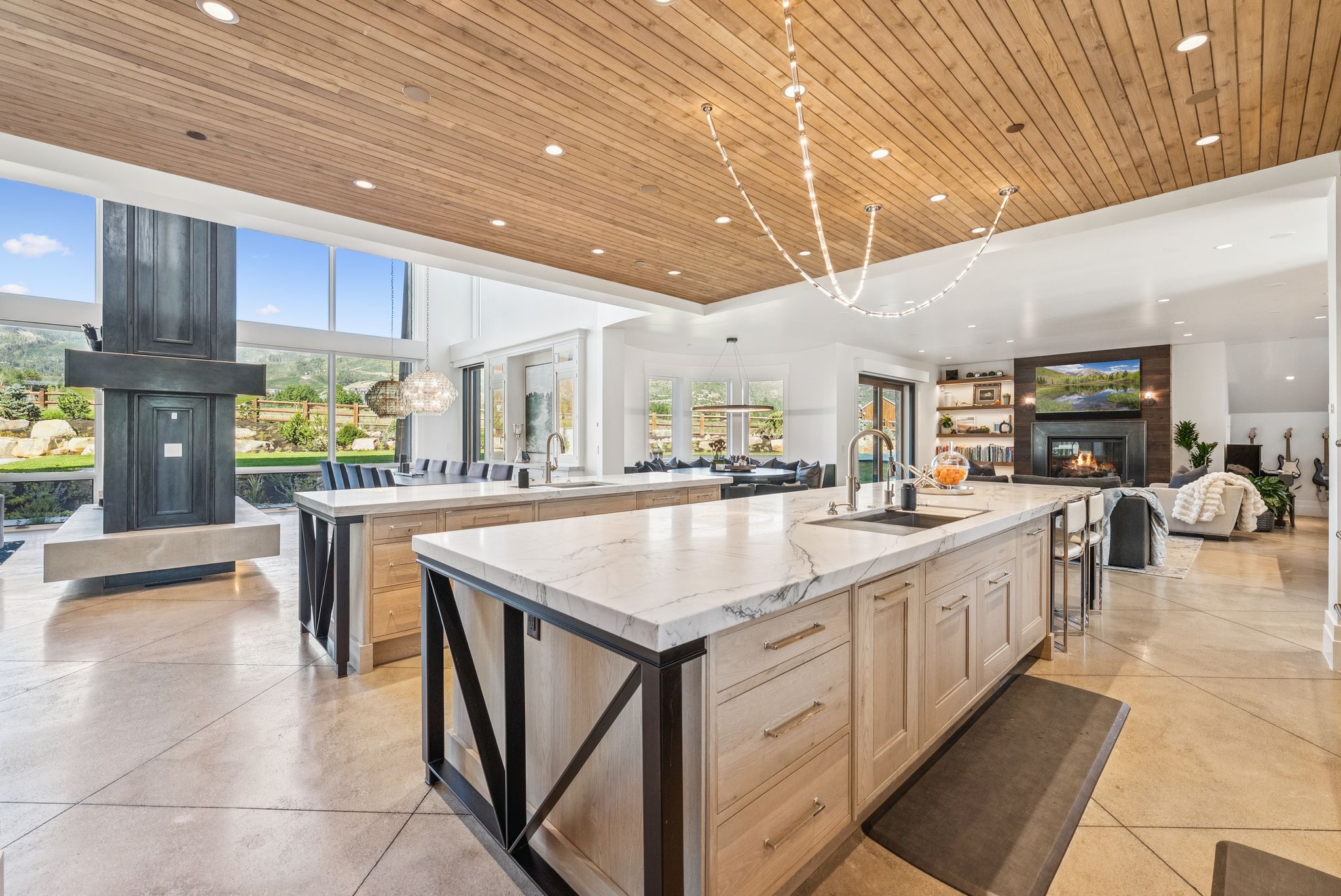 Kitchen with a large island, wooden ceiling, a glass covered fireplace, recessed lighting, and open floor plan