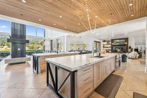 Kitchen with a large island, wooden ceiling, a glass covered fireplace, recessed lighting, and open floor plan