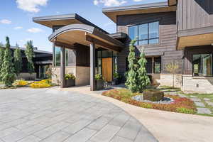 View of front of house with stone siding and a patio