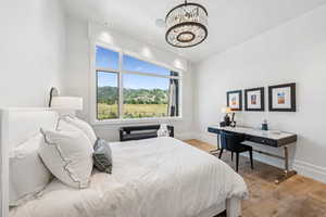 Bedroom with light wood-style floors, a chandelier, and recessed lighting