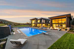 Outdoor pool with an outdoor hangout area, a patio, and a diving board