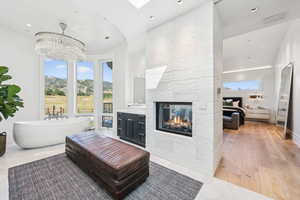 Living room featuring recessed lighting, a fireplace, light wood-style floors, and a chandelier