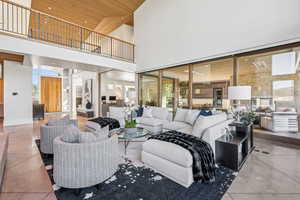 Living room with a towering ceiling, wooden ceiling, and healthy amount of natural light