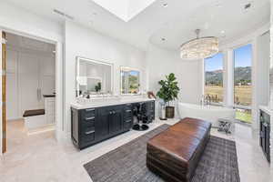 Bathroom featuring vanity, marble tiled flooring, a freestanding bath, recessed lighting, and a chandelier