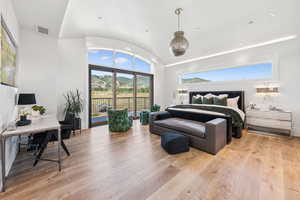 Bedroom with access to exterior, light wood-style flooring, vaulted ceiling, an office area, and recessed lighting