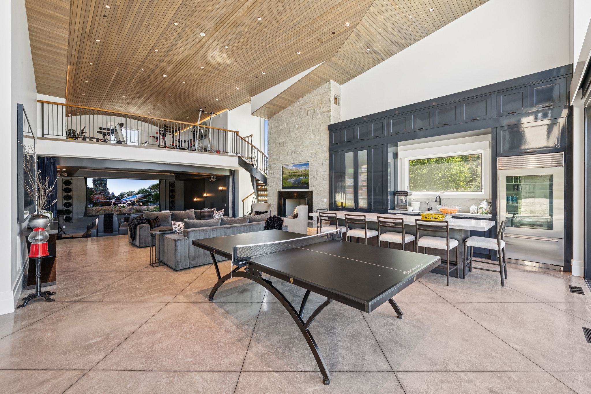 Game room with a towering ceiling, finished concrete floors, and wooden ceiling