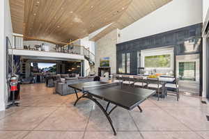Game room with a towering ceiling, finished concrete floors, and wooden ceiling