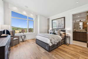 Bedroom featuring light wood-type flooring, connected bathroom, and recessed lighting