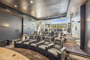 Carpeted cinema room with a tray ceiling and recessed lighting