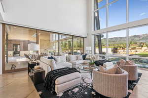 Living area with a mountain view, a high ceiling, plenty of natural light, and finished concrete flooring