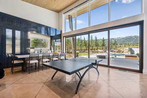 Rec room featuring a high ceiling, finished concrete flooring, and wooden ceiling