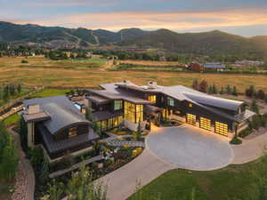 View of front of home featuring curved driveway, a mountain view, a metal roof, and a view of rural / pastoral area