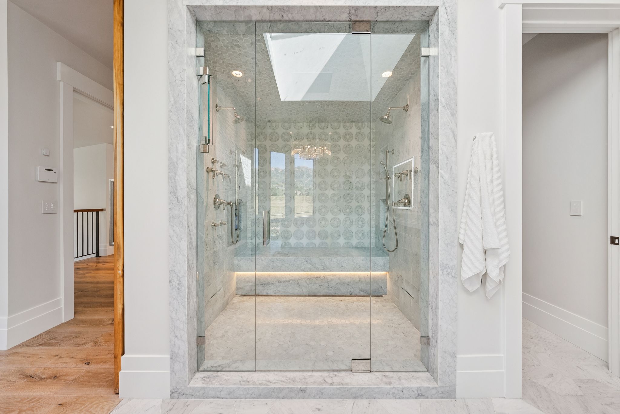 Bathroom featuring a shower stall, a skylight, and wood finished floors