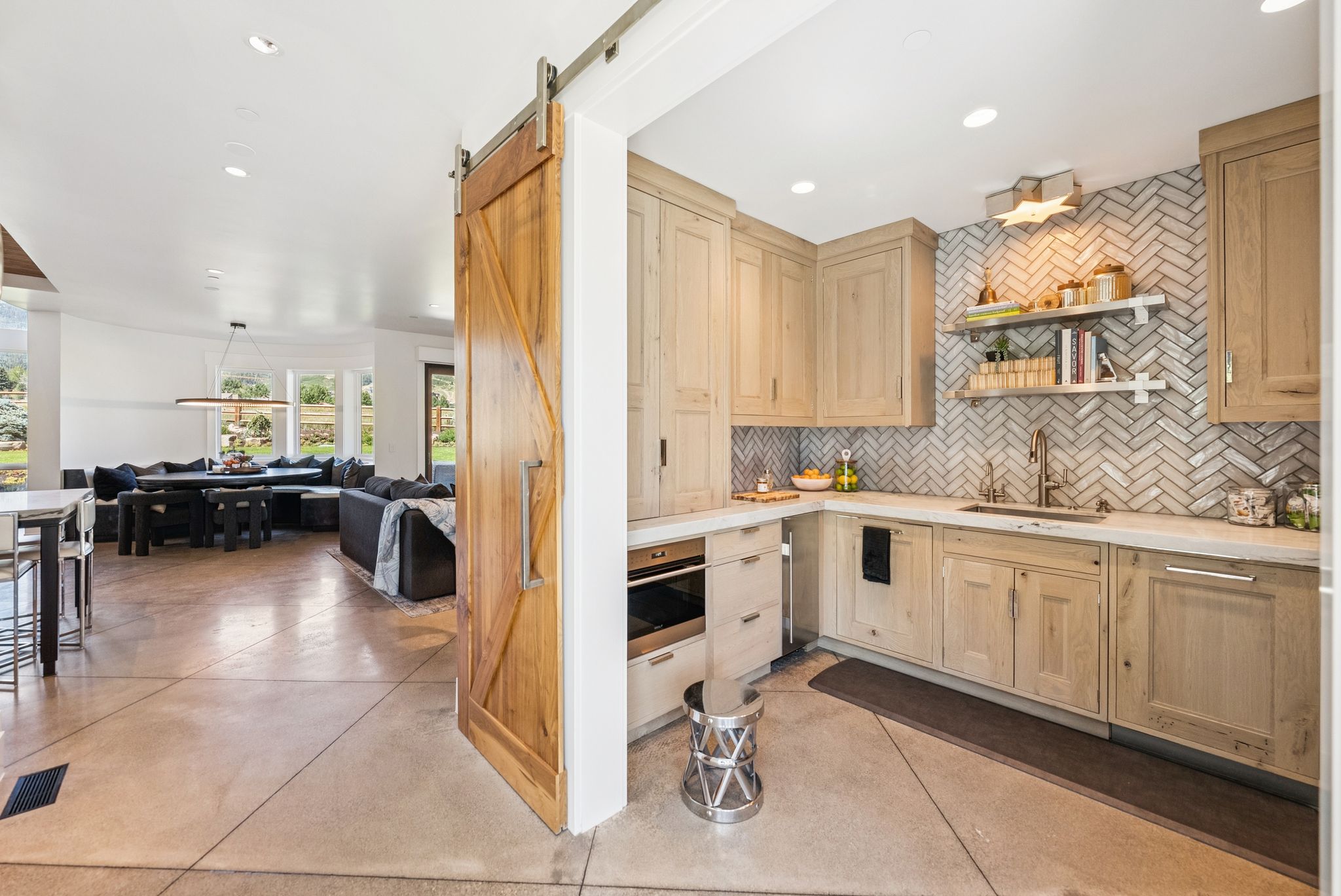 Kitchen with light brown cabinets, tasteful backsplash, light countertops, open floor plan, and recessed lighting