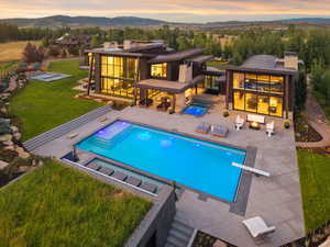 Swimming pool with an in-ground hot tub, outdoor lounge area, a mountain view, a lawn, and a diving board