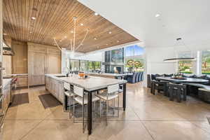 Kitchen with recessed lighting, wood ceiling, a large island, open floor plan, and light stone counters