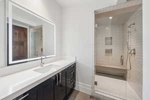Full bath featuring vanity, a shower stall, and tile patterned floors