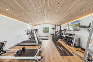 Exercise room with vaulted ceiling, recessed lighting, wood-type flooring, and wood ceiling