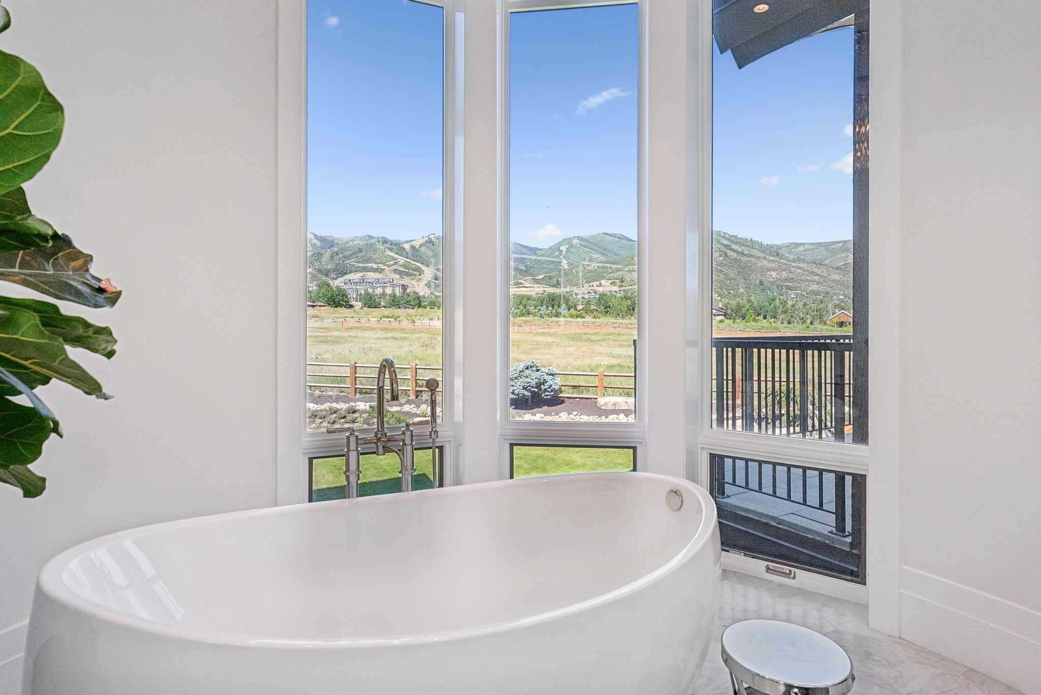 Full bath with a mountain view, plenty of natural light, and a soaking tub