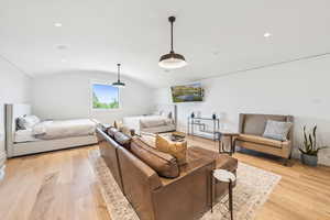 Living room with light wood-type flooring, vaulted ceiling, and recessed lighting