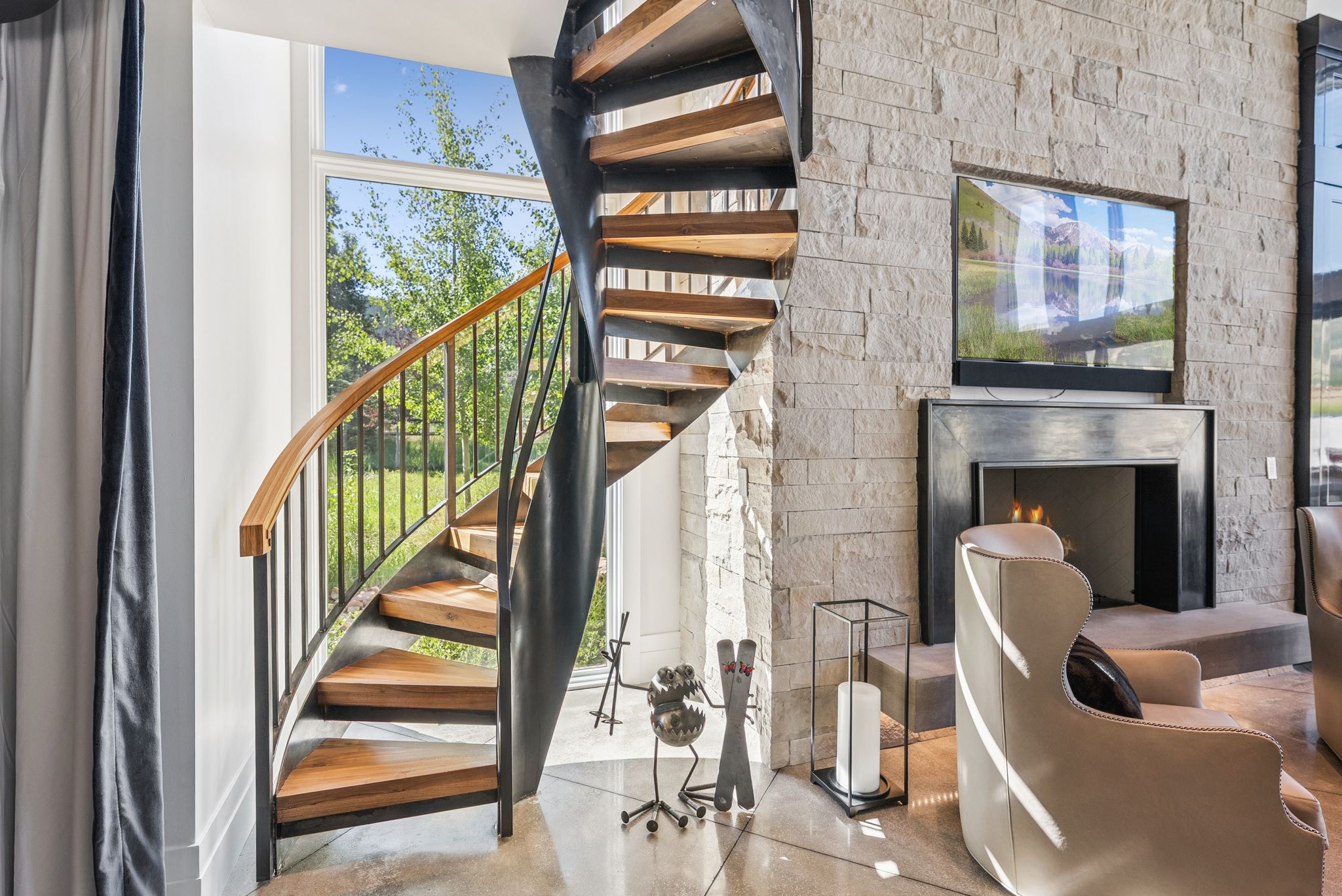 Stairs with finished concrete flooring and a warm lit fireplace