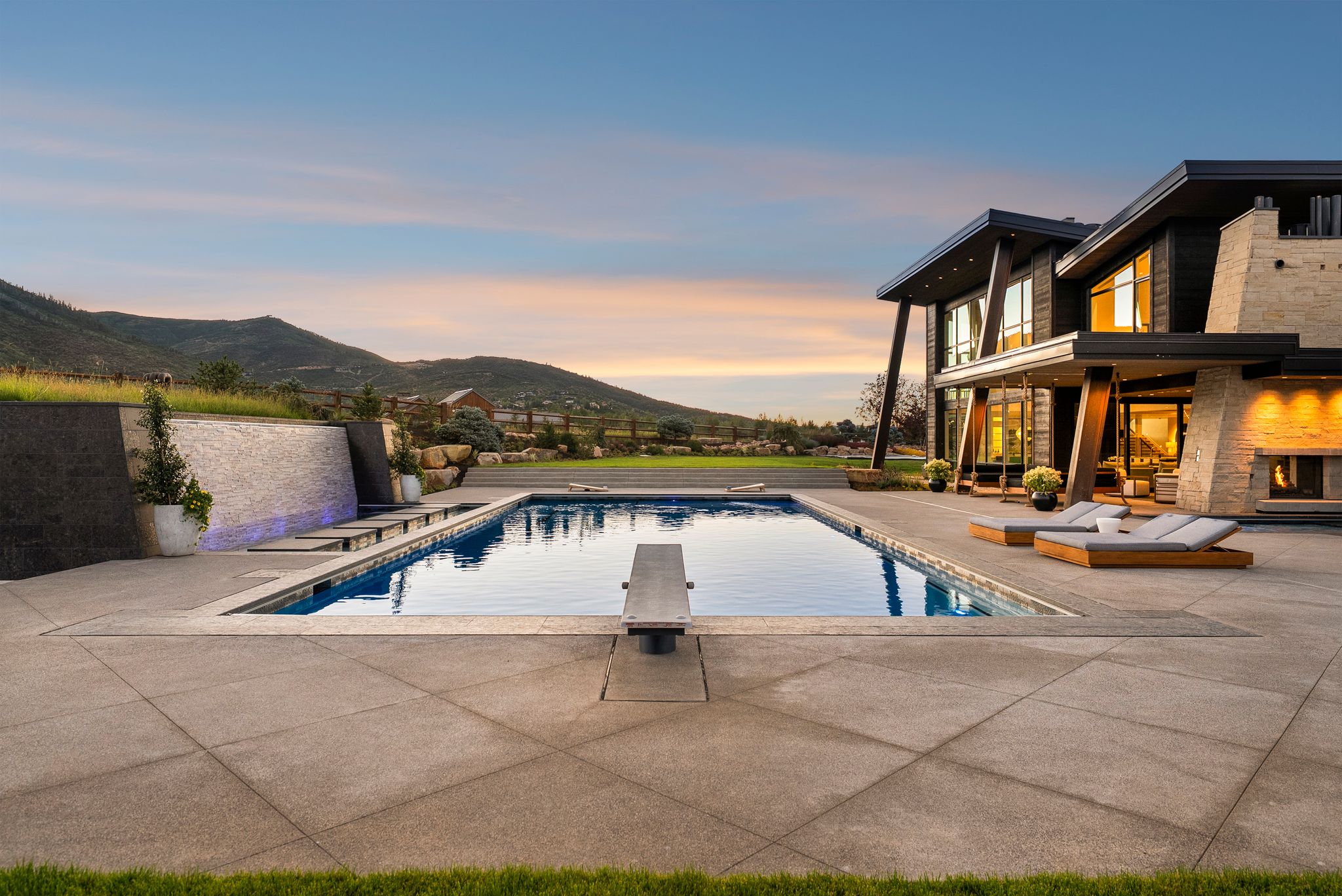 Swimming pool with a patio area, a mountain view, and a diving board