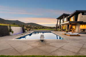 Swimming pool with a patio area, a mountain view, and a diving board