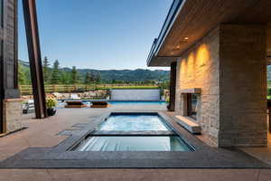 View of swimming pool featuring a mountain view, an in-ground hot tub, and a patio