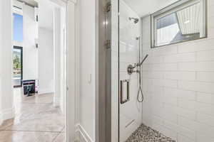 Bathroom featuring a shower stall and finished concrete floors