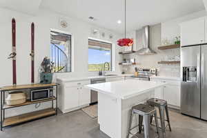 Kitchen featuring open shelves, finished concrete flooring, stainless steel appliances, tasteful backsplash, and white cabinetry