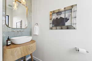Bathroom with a sink and tasteful backsplash