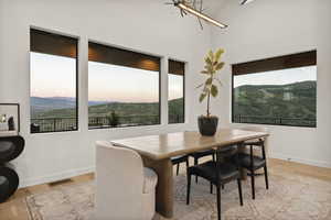 Dining room featuring light wood finished floors, a chandelier, and a mountain view