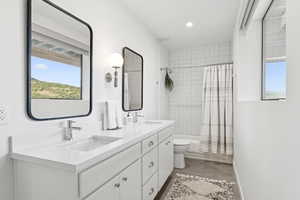 Full bath featuring double vanity, shower / bath combo, and recessed lighting