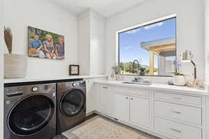 Laundry room featuring separate washer and dryer and cabinet space