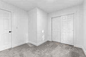 Unfurnished bedroom with carpet and a closet