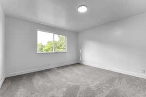 Carpeted empty room featuring baseboards