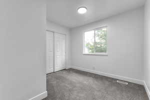 Unfurnished bedroom with carpet and a closet