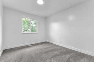 Carpeted spare room with baseboards