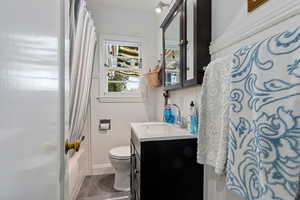 Bathroom with vanity and shower / bath combo with shower curtain