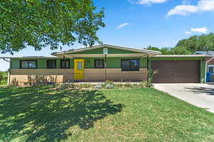 View of front facade with a garage, driveway, brick siding, a front yard, and a porch