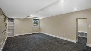 Below grade area with dark colored carpet and recessed lighting
