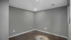 Spare room with dark wood-style floors and recessed lighting