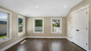 Unfurnished bedroom with dark wood finished floors, vaulted ceiling, recessed lighting, and a closet