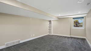 Basement with dark carpet and recessed lighting