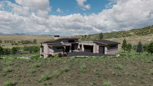Rear view of house with stone siding, a chimney, board and batten siding, and a mountain view