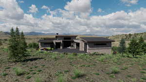 Rear view of property featuring stone siding, a mountain view, board and batten siding, and an attached garage