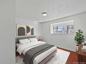 Bedroom with a textured ceiling and light wood finished floors