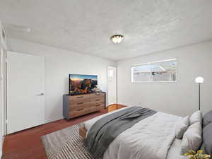 Bedroom with wood finished floors and a textured ceiling