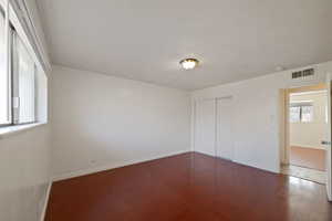 Unfurnished bedroom featuring wood finished floors and a closet